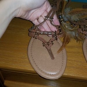 Brown ankle wrap sandals with feather detail.